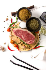 raw steak cutting board spices top view