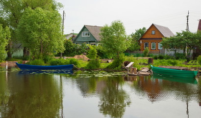 Obraz premium Village on the banks of the river with boats