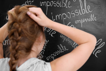 Girl thinking in front of chalk board