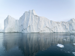 Fototapeta na wymiar Arctic Icebergs Greenland in the arctic sea. You can easily see that iceberg is over the water surface, and below the water surface. Sometimes unbelievable that 90% of an iceberg is under water
