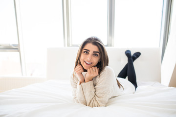 Beautiful woman lying on white bed