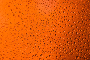 misted glass of beer close up an orange bright background