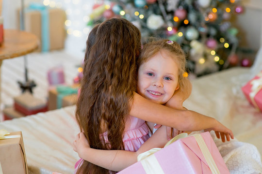 Two young girls give each other gifts