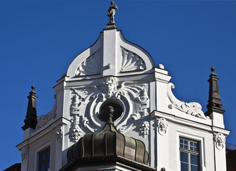 Art deco architecture:garret round window decorated by sculpted mask and ornamental motives on the top of an ancient building in Munich