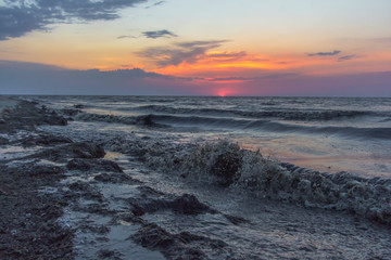 Sunrise on sea beach. Black water, ocean pollution, ecology disaster dirty sea. Effect of Human Activities on the Environment.