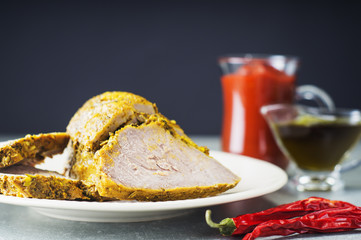 Sliced pastrami.Delicious homemade baked meat. Savory meat, pastrami on a plate with red pepper and spices. Appetizing roast beef. Sliced pastrami. 