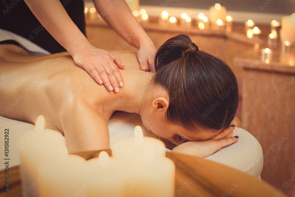 Wall mural relaxed girl getting massage at spa