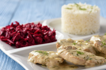 Grilled pork tenderloin in sour cream sauce with dill served with rice and beetroot salad.