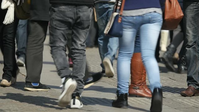 Legs and feet on a busy street in Amsterdam on a sunny day. Long lens.