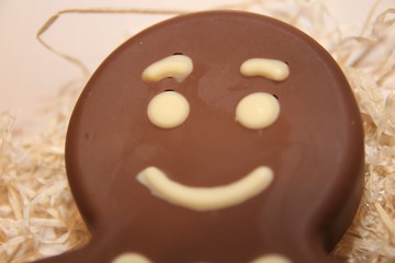 Figure  chocolate man decorated colored icing and being eaten. Holiday chocolate in shape of man for new year's day, christmas, winter holiday. 