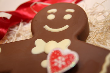 Figure  chocolate man decorated colored icing and being eaten. Holiday chocolate in shape of man for new year's day, christmas, winter holiday. Heart