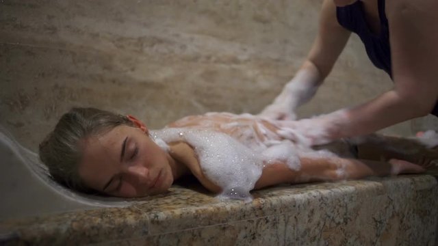 A cheerful brunette smiling, relaxing and enjoying the turkish bath closeup