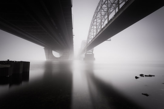 Long exposure shot of two parallel bridges over foggy autumn river. Kiev. Ukraine.