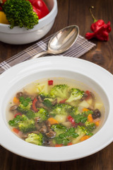 Vegetable soup with broccoli, mushrooms and herbs. Wooden background. Top view. Close-up