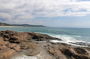 Fototapeta na wymiar Rocky Shoreline Against Ocean Sky Coastal Landscape