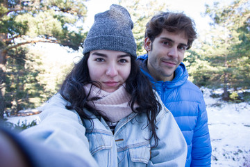 Couple of lovers enjoying in the snow doing a selfie. They are happy, spending a day of vacation in the mountains. - happiness, love, couple, time together concept 