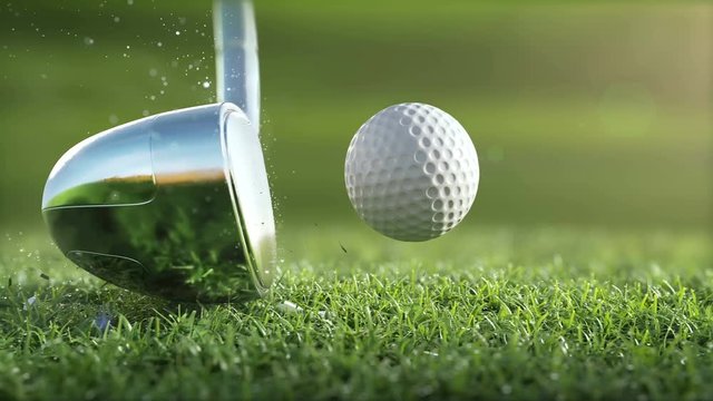 Golf club hits a golf ball in a super slow motion, in sunny morning. visible deformation of the ball, drops of dew and grass particles after impact raised in the air. Ultra-realistic 3D animation