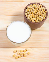 Glass of soy milk on a wooden background.