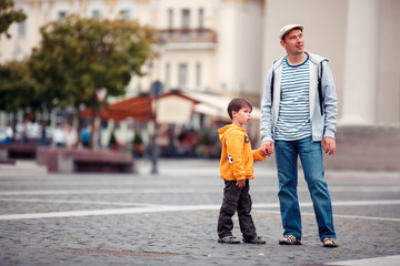 Father and son walking outdoors in city