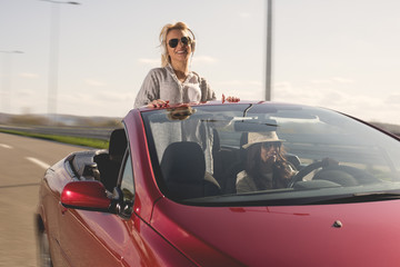 Two Beautiful young women sitting in the car and enjoy in driving.Colored photo