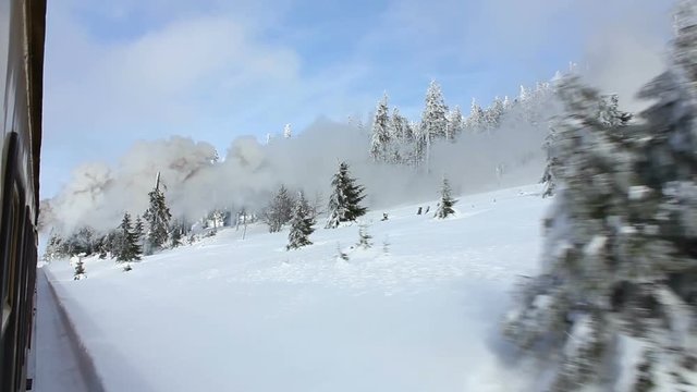 Steam train drives through winter landscape