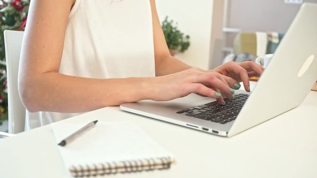 Close-up of a young woman working on a laptop. Slow Motion