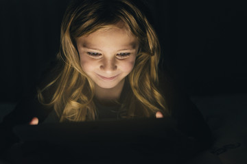 Sweet blondie girl playing on a Tablet.