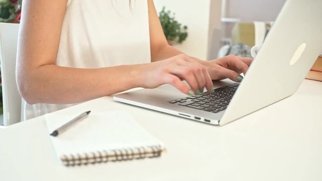 Close-up of a young woman working on a laptop. Slow Motion