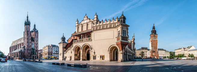 Panorama of Main Market Square (Rynek) in Cracow, Poland with the Renaissance Drapers' Hall (Sukiennice), Gothic St Mary church, medieval city hall tower. The biggest medieval market square in Europe - obrazy, fototapety, plakaty