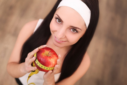 Closeup on measuring apple in caucasian woman`s hands.