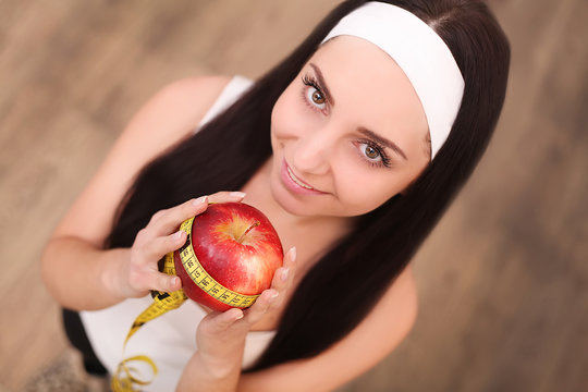 Healthy happy woman with apple and tape measure for diet and weight loss concept