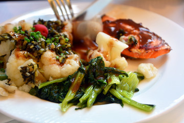 Salmon with wasabi and vegetables on a plate. Japanese food.