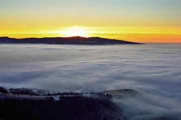 Landscape with trees and fog. Winter inversion in Slovakia. Freeze land. Low sky scenery at sunrise.