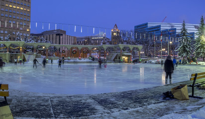 Families ice skating at Olympic in Calgary, Alberta. The ice skating at Olympic Plaza is a popular winter activity for Calgarians.