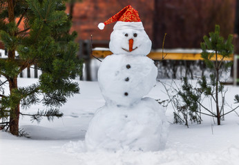 Obraz premium Smiling Snowman in a Santa Claus hat