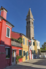 Colourfully painted houses and Leaning tower on Burano island, Italy.