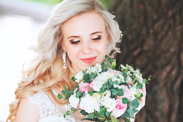 Naklejka premium Beautiful bride. Wedding hairstyle and make up.Young bride in wedding dress holding bouquet