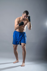 Obraz premium Portrait of kickboxer on a gray background.