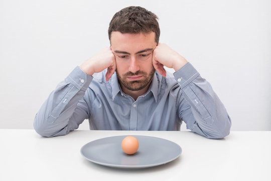 Hungry Man Feeling Sad In Front Of A Dish With An Egg