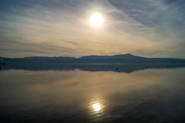 Fototapeta premium Sunset on lake, with mountains and snow on background