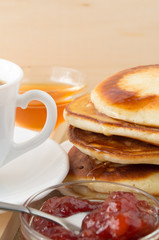 Pancakes with honey and jam and white cup of tea