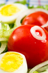 Cherry tomatoes and boiled eggs in a salad with lettuce leaves
