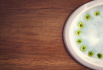 Sink on wooden tabletop with flowers around