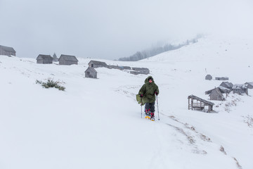 Fototapeta na wymiar Man hiking in winter mountains before thunderstorm