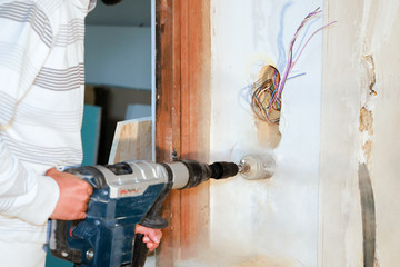 electrician holding power drill with gypsum hole saw drill bit,