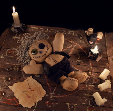Voodoo doll in pentagram circle on woden planks.