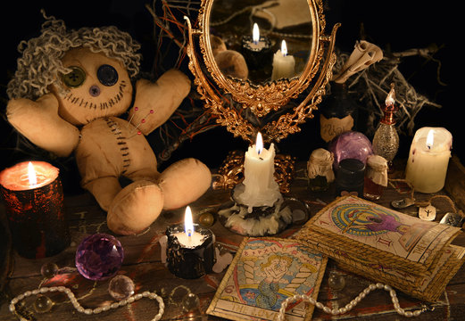 Magic ritual with voodoo doll, mirror and tarot cards