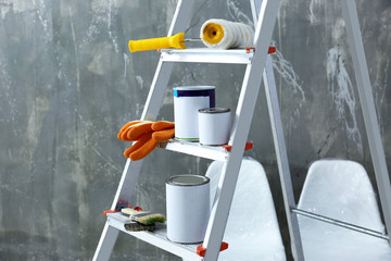 Ladder and set of tools for repair near grunge wall, closeup