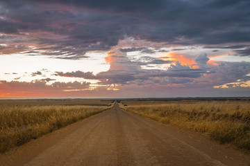 Dramatic moody sunset over dirt road in rural Australian outback