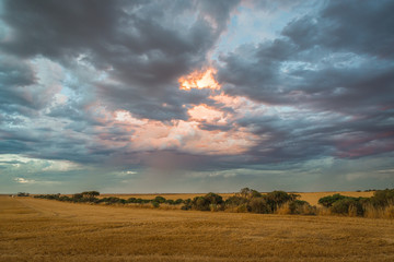 Dramatic moody sunset over dirt road in rural Australian outback